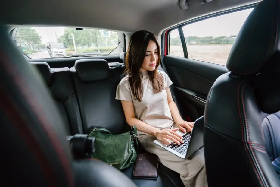 Woman using a laptop in a taxi